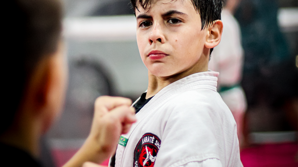 Criança com faixa branca no karate infantil em Curitiba