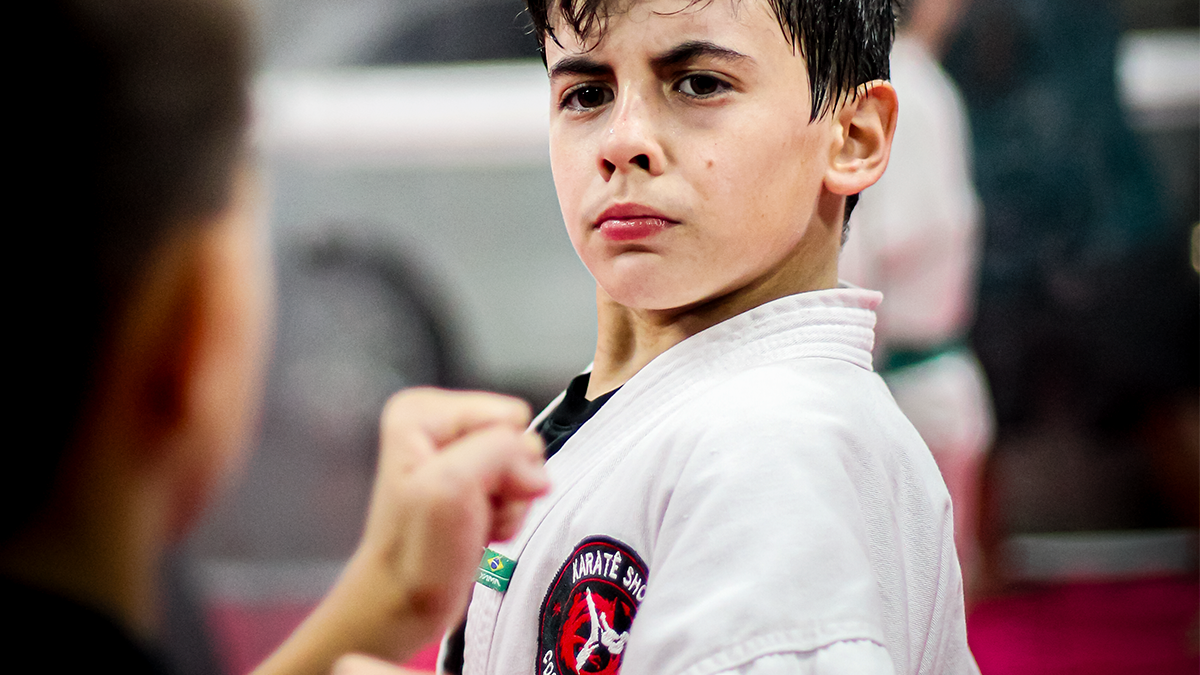 Criança com faixa branca no karate infantil em Curitiba